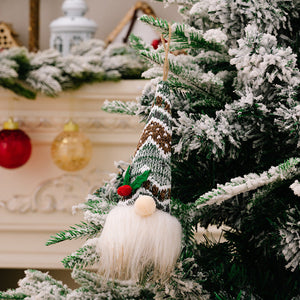 Knitted gnome ornament with a white beard and a patterned hat in green, brown, and white.