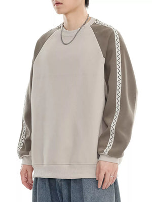 Oversized raglan sleeve sweatshirt in gray apricot with decorative zigzag trim on sleeves.