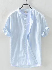 Light blue linen short sleeve henley shirt with rolled cuffs and button front.