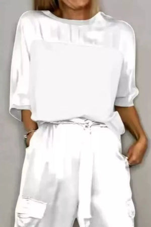 White satin two-piece ensemble with drawstring waist pants and a loose-fit top.
