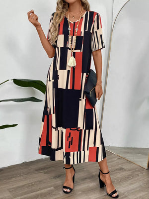Geometric V-neck midi dress in dark blue, red, and cream with short sleeves.