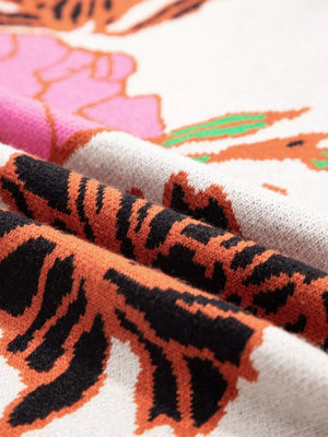 Knit sweater with floral and tiger print, featuring a stand neck and quarter zip detail.