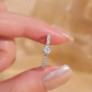 Elegant sterling silver ring with a brilliant moissanite center stone and pave accents.