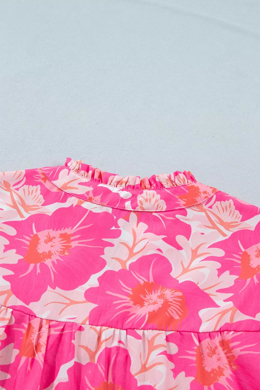 Vibrant floral print polyester blouse with ruffled mock neck and bubble sleeves.