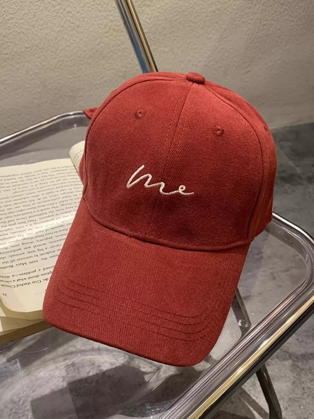 Burgundy baseball cap with embroidered white "me" text detail