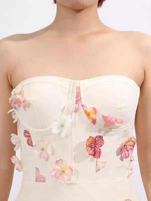 Cream strapless tulle maxi dress with floral appliques and sweetheart neckline.
