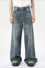 Oversized patchwork distressed denim trousers in medium wash cotton with a wide leg and casual styling.