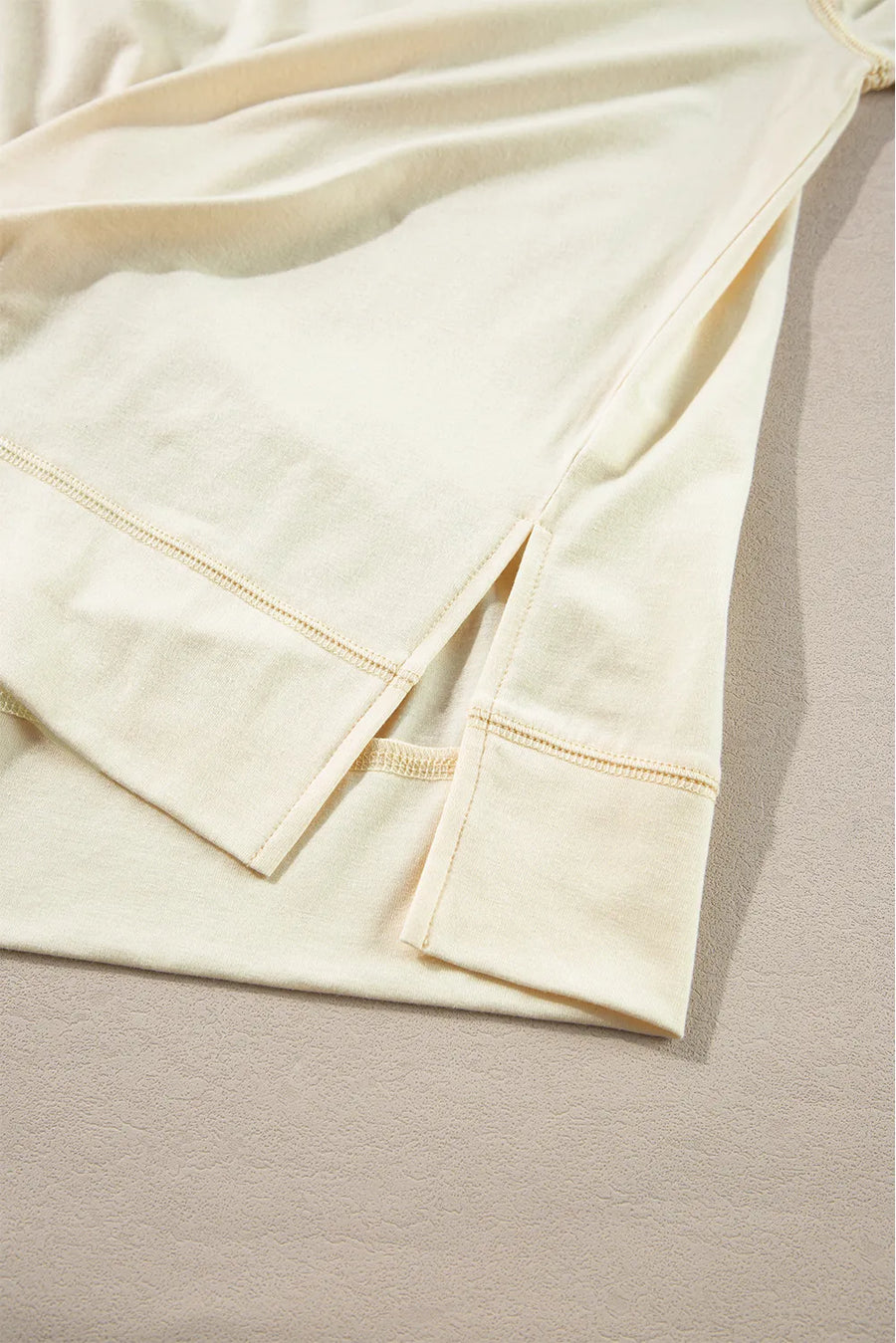 Pastel yellow blouse with side slits and reinforced hem detail.