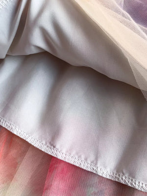 Floral tiered midi dress detail with smocked bodice, showing layered fabric and hem stitching.