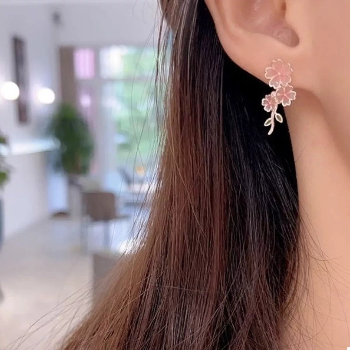 Blush pink asymmetrical floral drop earrings with alloy stem detail.