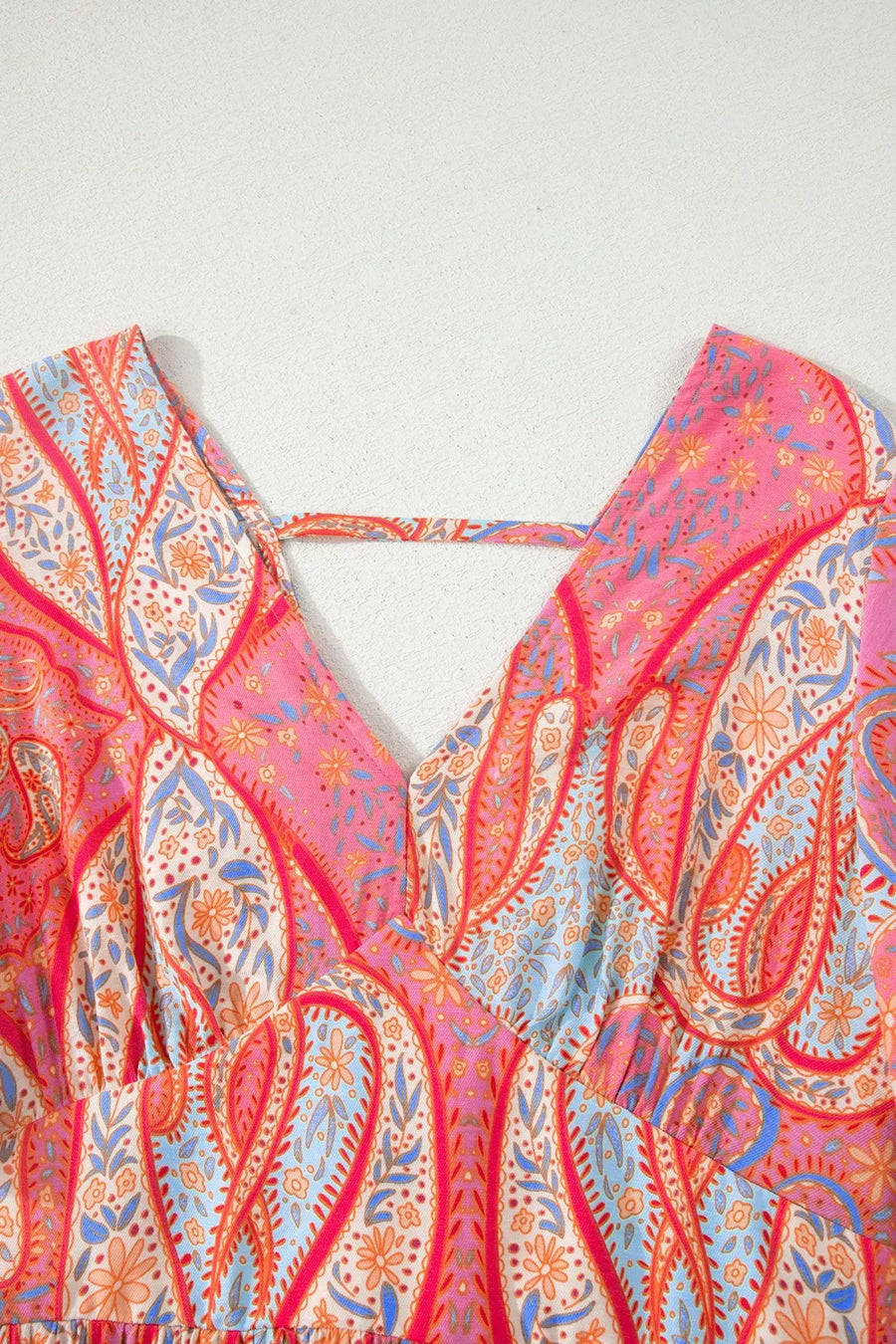 Paisley print v-neck boho dress with criss-cross back detail in burnt coral and pink.