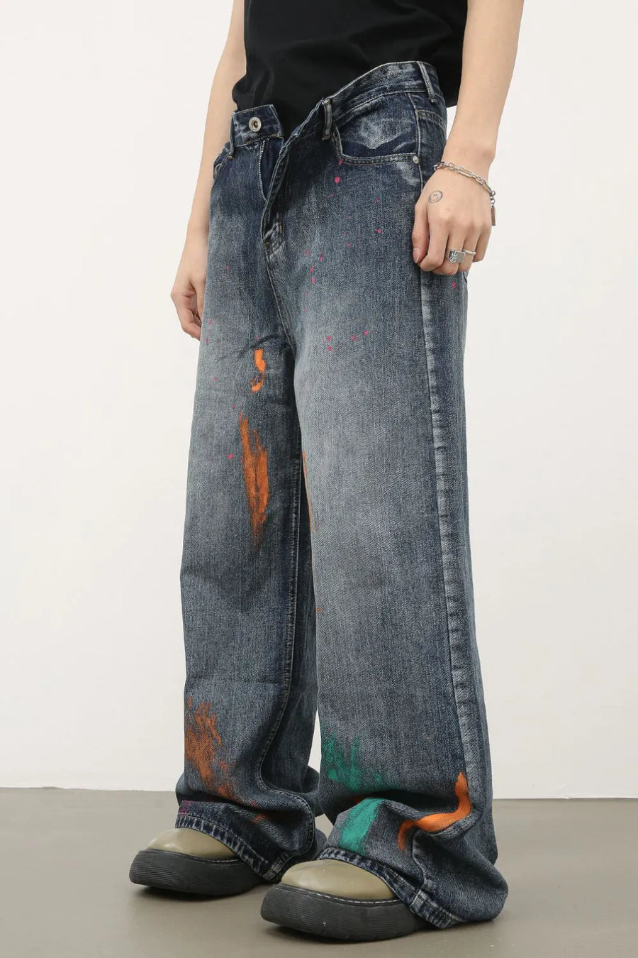 Painterly wide-leg denim jeans in medium wash with abstract paint splatters and wide leg cut.
