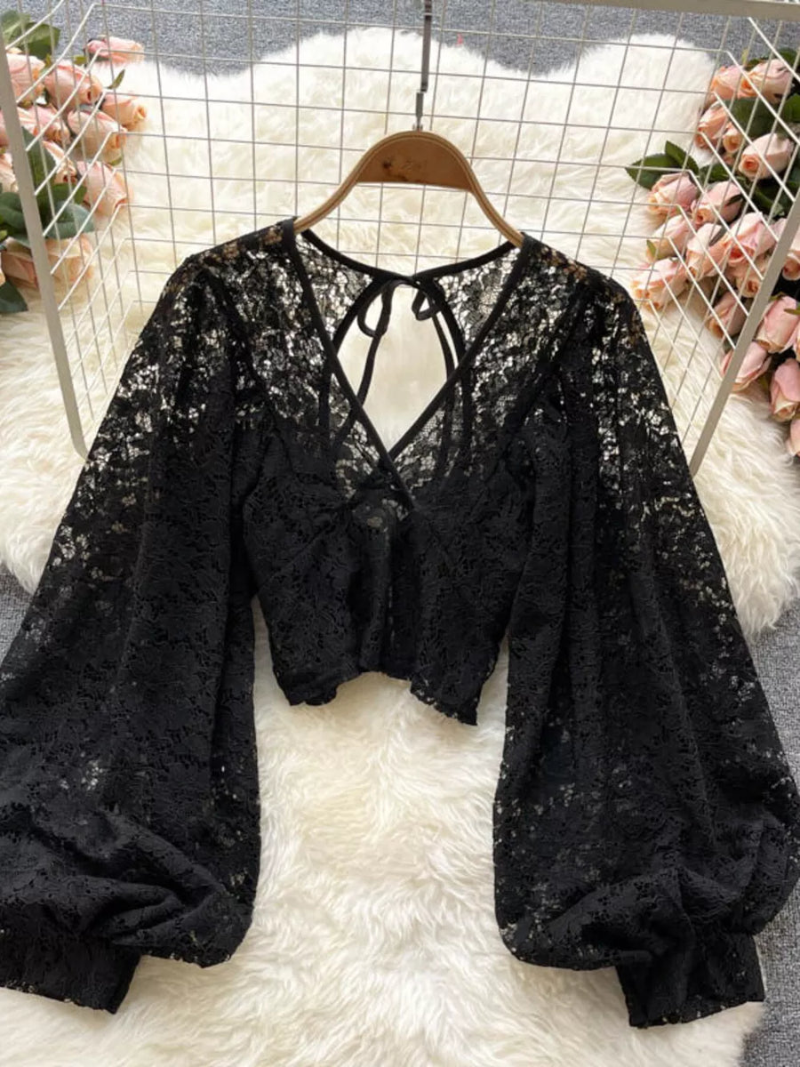 Black sheer floral lace cropped shirt with balloon sleeves and tie-back detail.