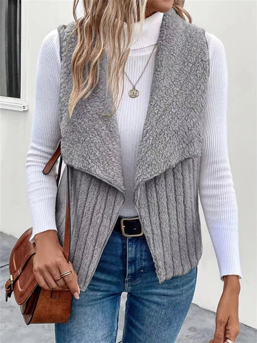 Gray open front fleece vest with ribbed texture and shawl collar, styled with jeans.