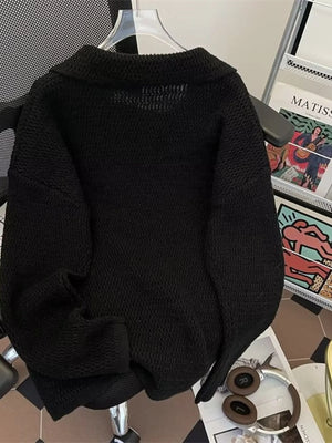 Black textured knit polo collar sweater with a relaxed fit.
