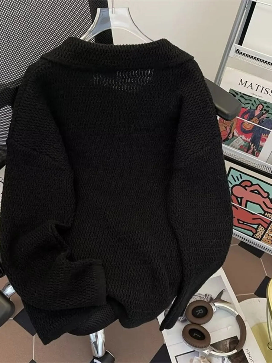 Black textured knit polo collar sweater with a relaxed fit.