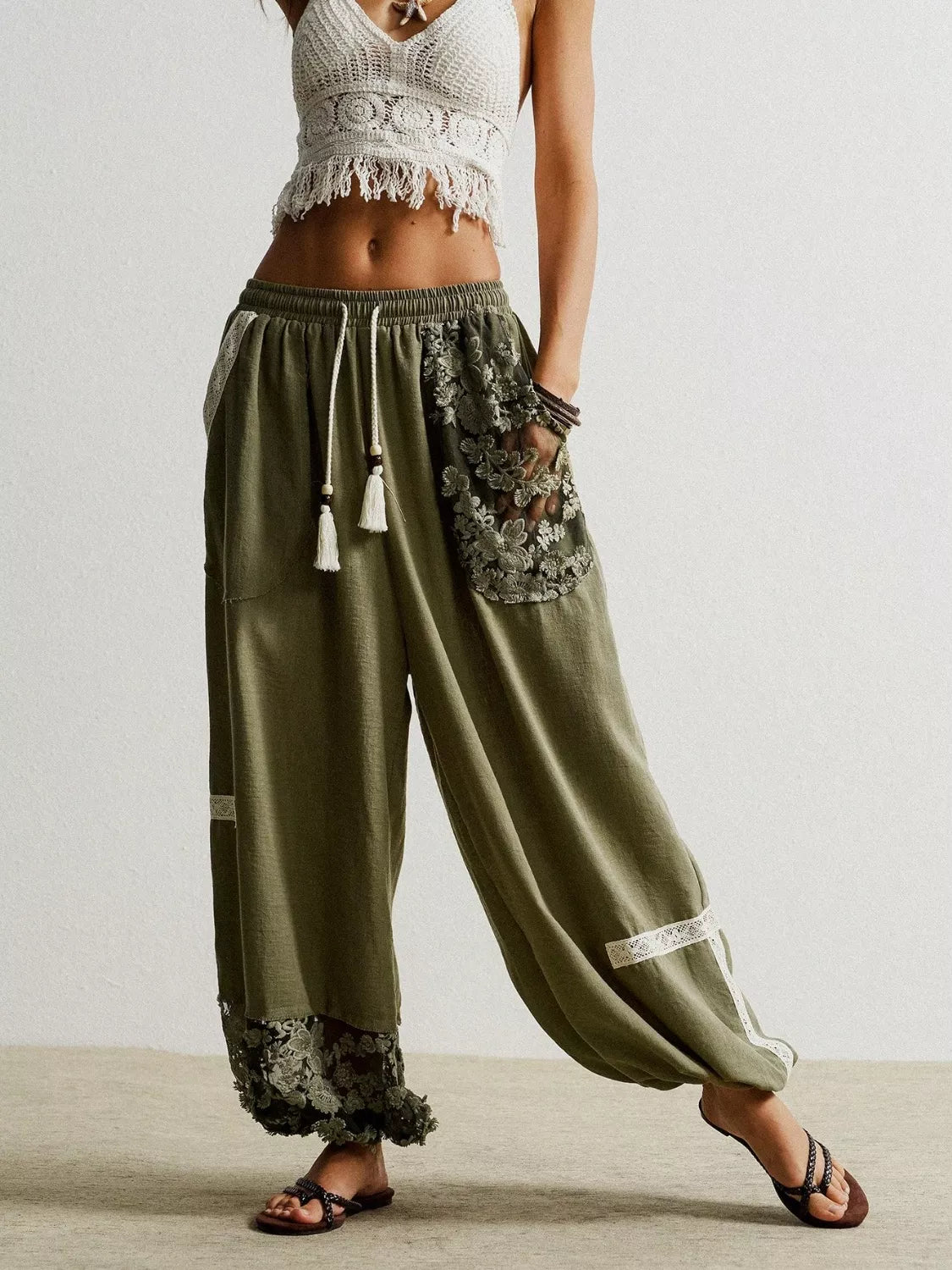 Moss drawstring harem pants with lace trim and floral embroidered pockets.