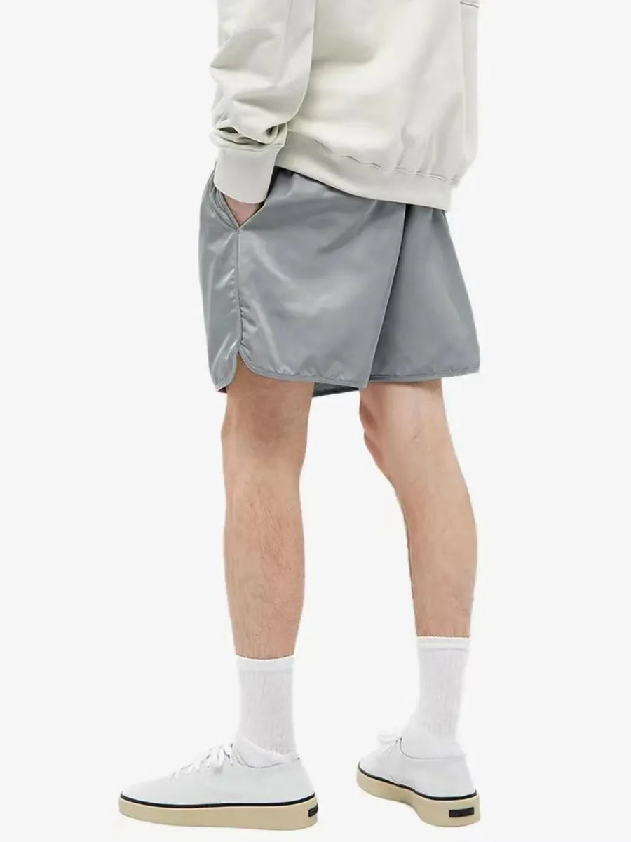 Nylon drawstring shorts in Dark Gray with curved hem detail and side pockets.