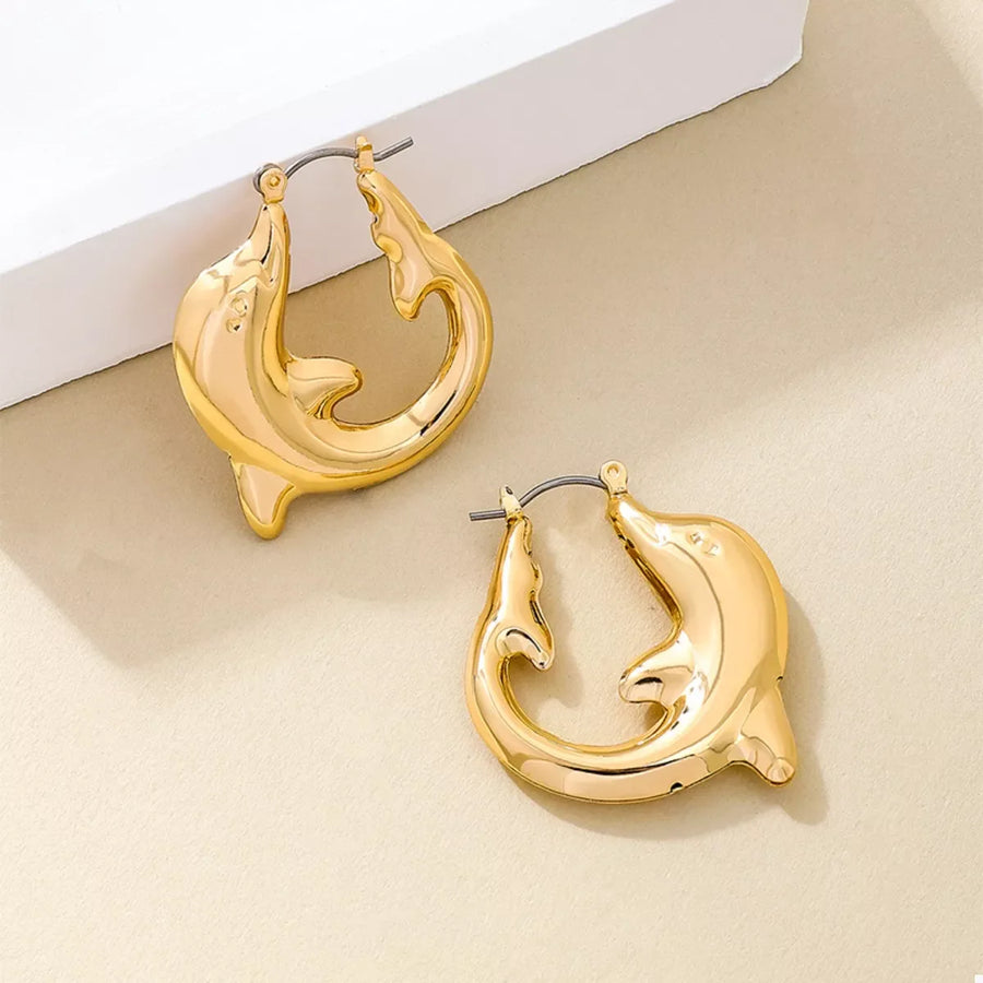Gold dolphin hoop earrings with a sleek, polished finish.