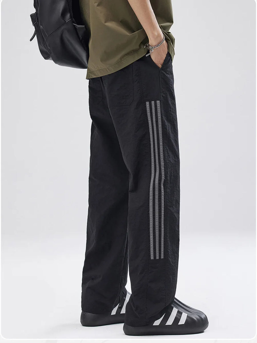 Black men's joggers with reflective side stripes and drawstring waist.