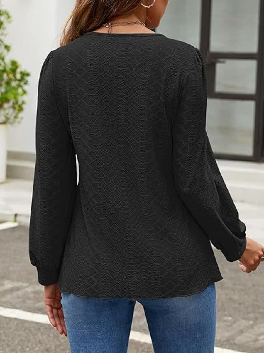 Black perforated puff sleeve blouse with textured fabric and balloon sleeves.