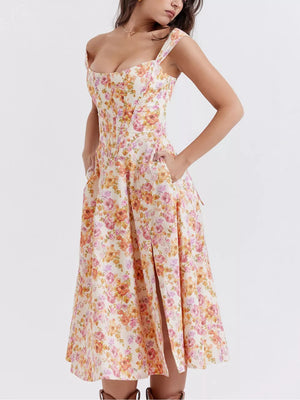 Floral midi dress with side slit, sweetheart neckline, and pockets in a pink and orange floral print.