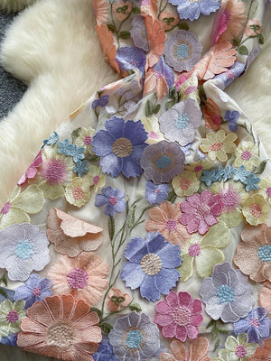 Embroidered floral mini dress with 3D applique flowers in pastel colors on sheer fabric.