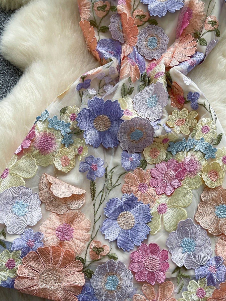 Embroidered floral mini dress with 3D applique flowers in pastel colors on sheer fabric.
