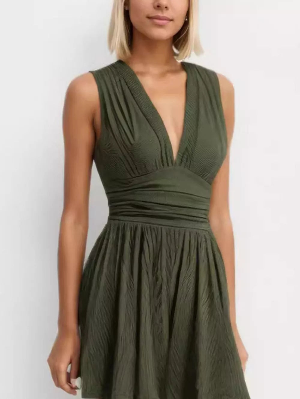 Army green ruched deep V-neck romper with cinched waist and a-line skirt.