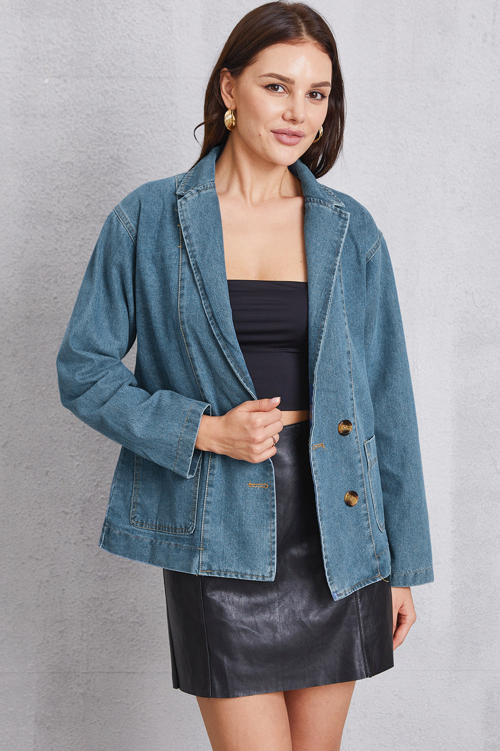 Medium wash denim blazer with tailored seam detailing and button closure.