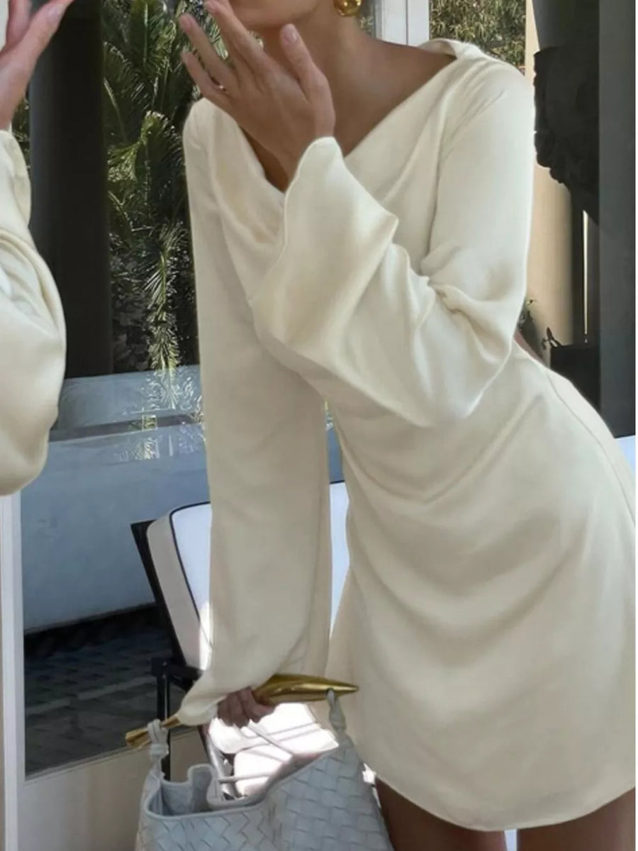 Cream long sleeve mini dress with draped neckline and flared cuffs.