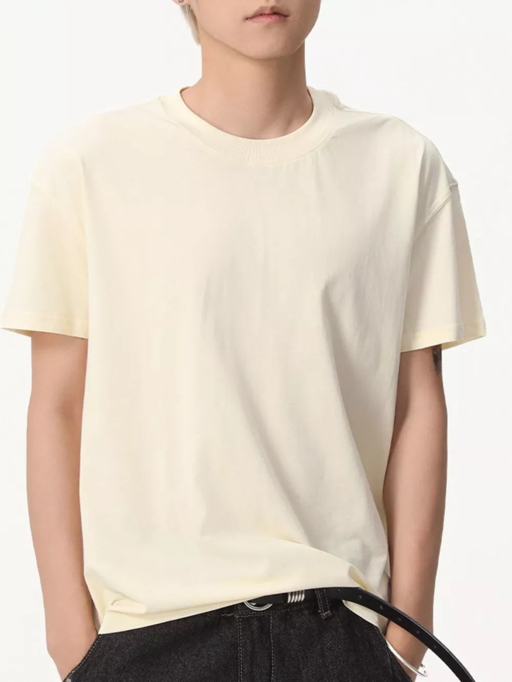 Cream cotton crew neck t-shirt with relaxed fit and short sleeves.