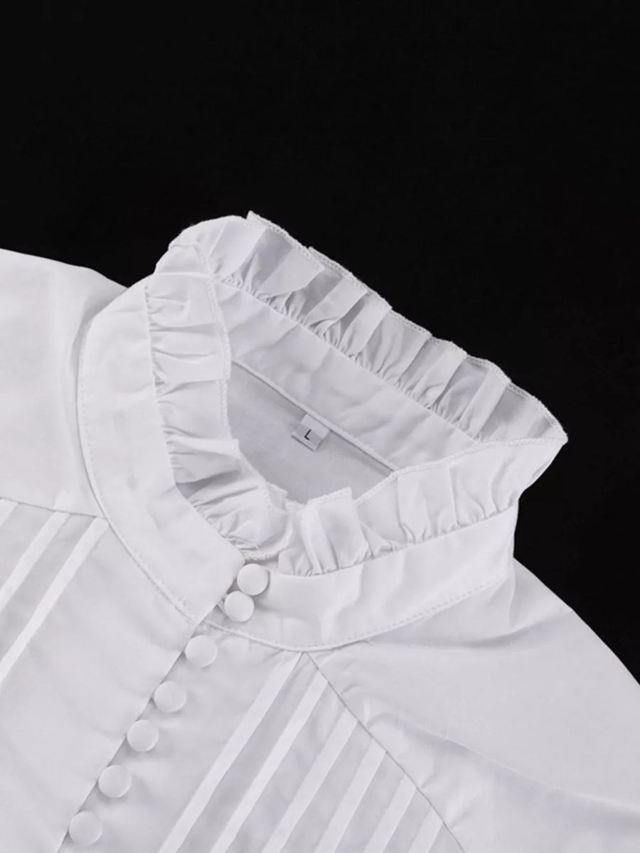 White cotton blouse with ruffled high neck and pintuck details.