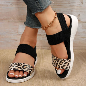 Leopard print elastic strap sandals with black straps and white soles.
