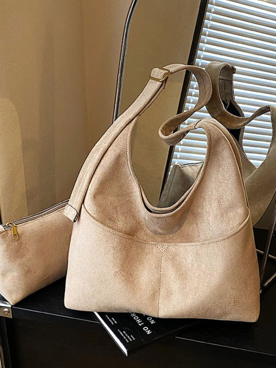 Khaki suede shoulder bag with adjustable strap and front pocket detail.