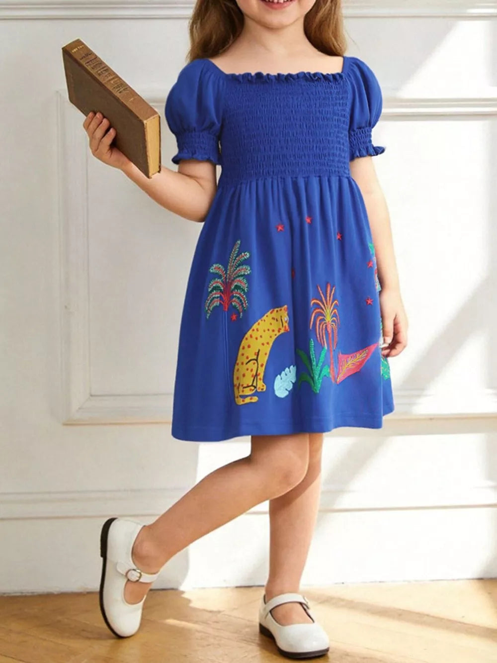 Blue cotton dress with smocked bodice, puff sleeves, and jungle animal print.
