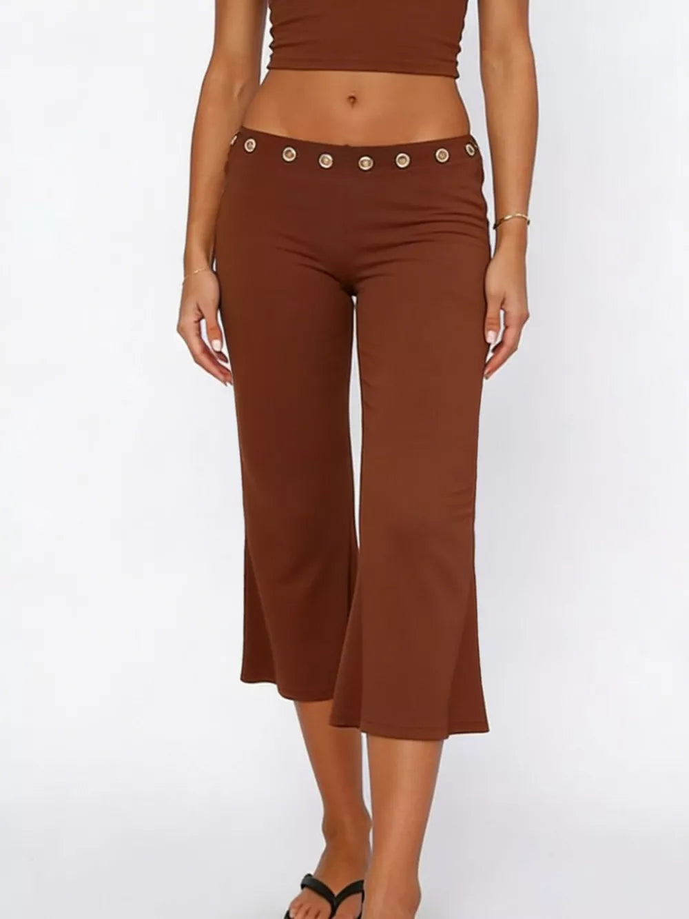Flared hem capri pants in dark brown with button detail at the waist.