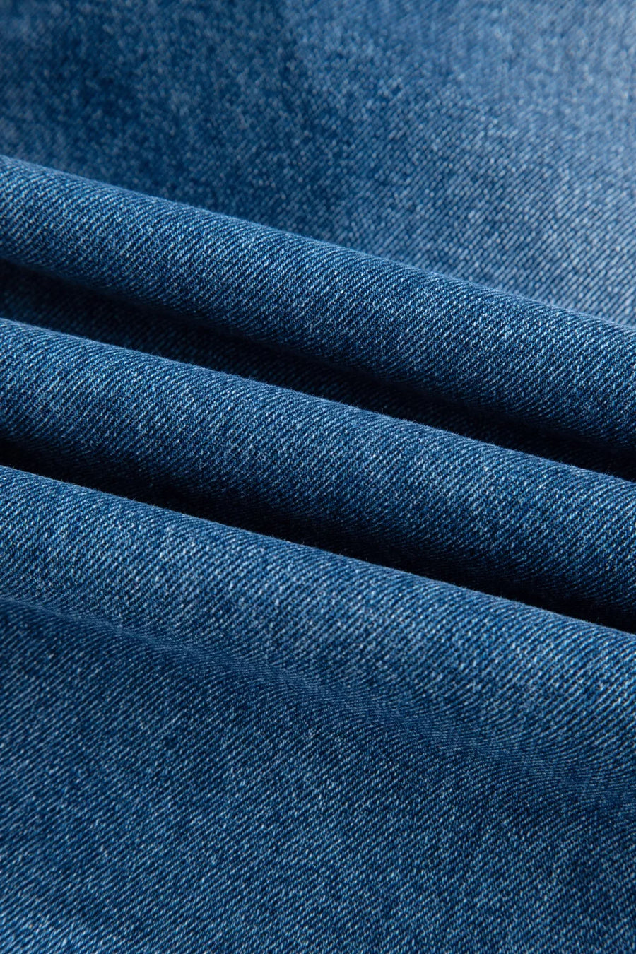 Denim overalls in a medium blue wash with a visible twill weave texture.