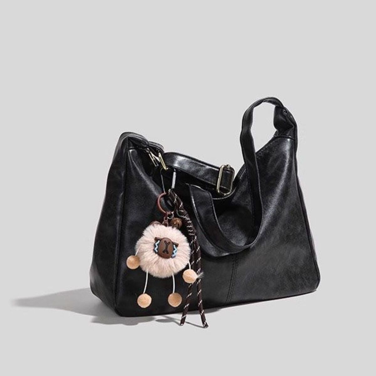 Black vintage hobo shoulder bag with sheep charm and tassel detail