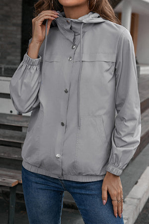 Light gray hooded utility jacket with drawstring waist and button front.