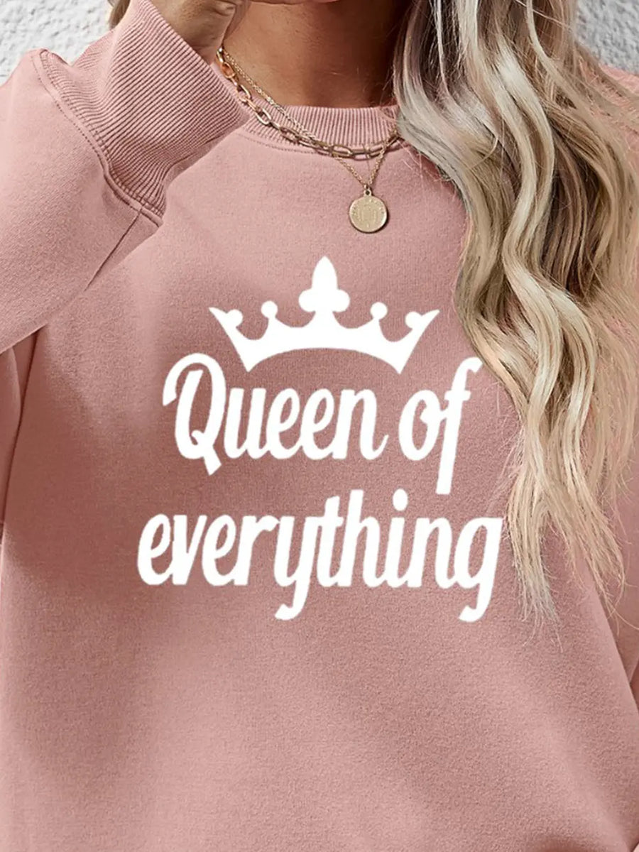 Blush pink graphic sweatshirt with white "Queen of everything" text and crown graphic.