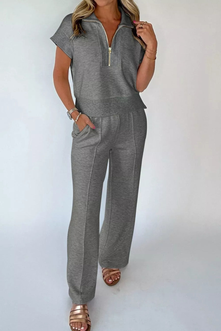 Dark gray half-zip polo shirt and wide-leg pants set with gold zipper detail.
