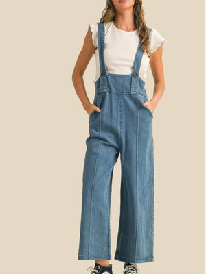 Vintage denim wide leg overalls with adjustable straps and button details, styled casually.
