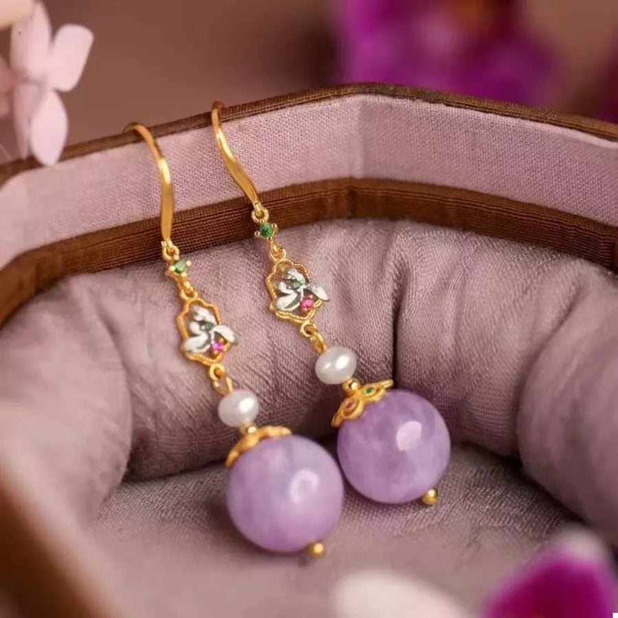 Elegant purple pearl drop earrings with gold floral accents and enamel details.