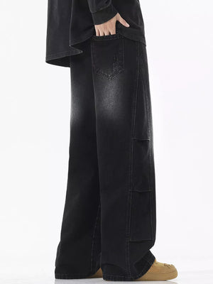 Men's black vintage wash wide leg jeans with distressed detail and patch pockets.