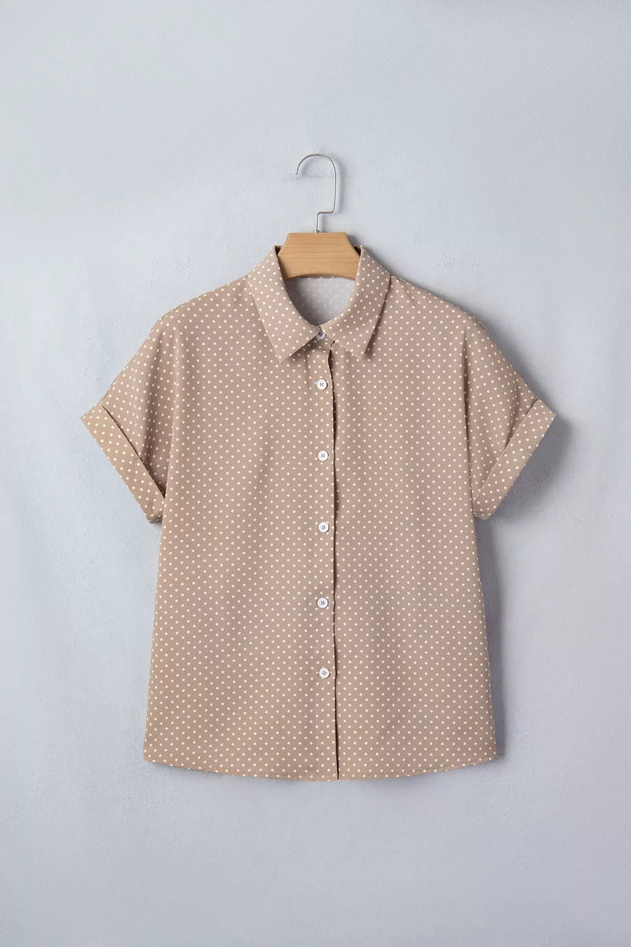 Chic polka dot button-up shirt with cuffed short sleeves.