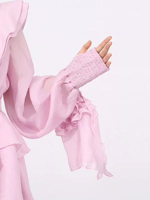 Pink tiered ruffle mini dress with smocked cuffs and flowing sleeves.