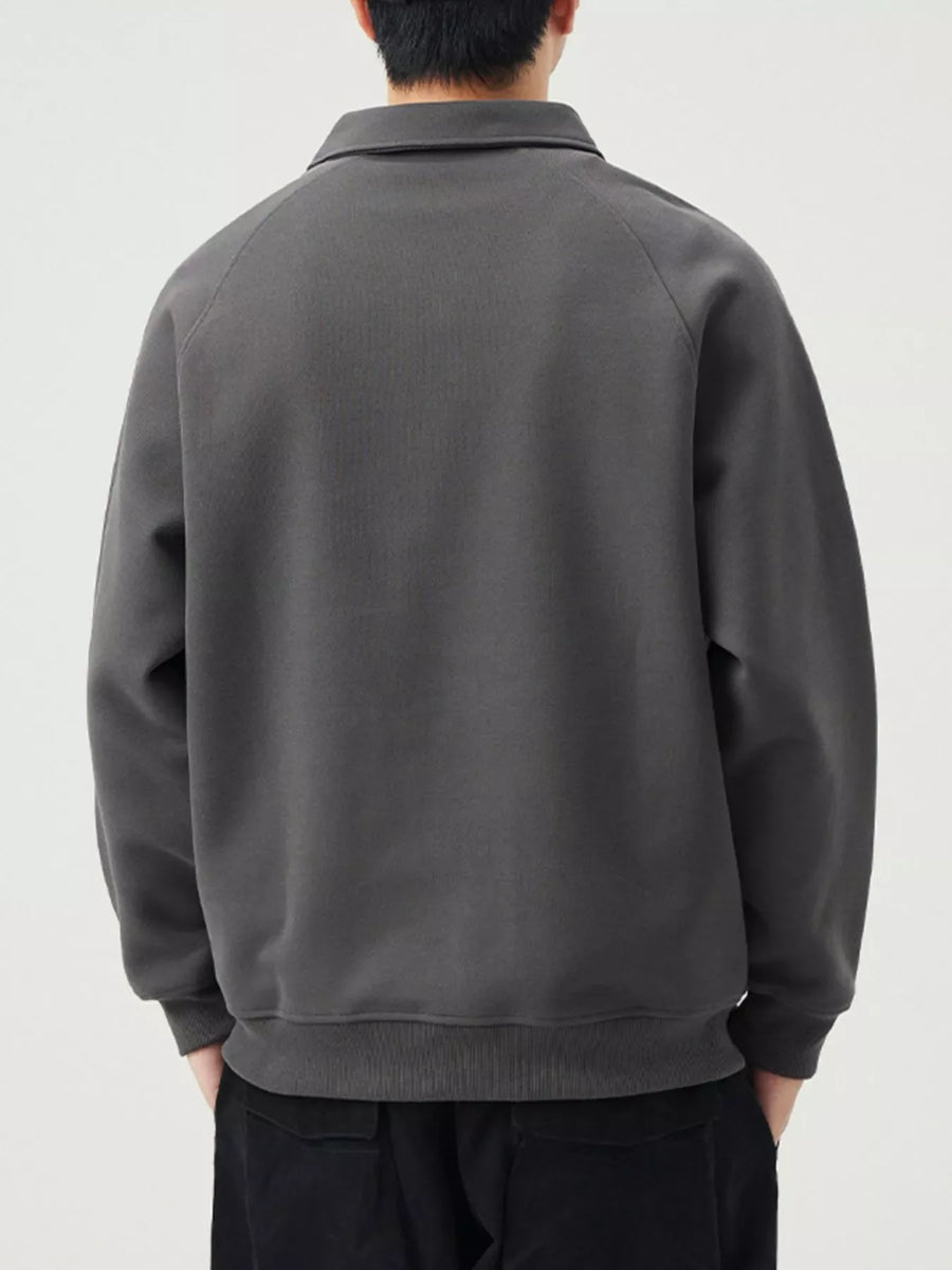 Dark gray raglan quarter zip sweatshirt with a collared neckline and ribbed cuffs and hem.