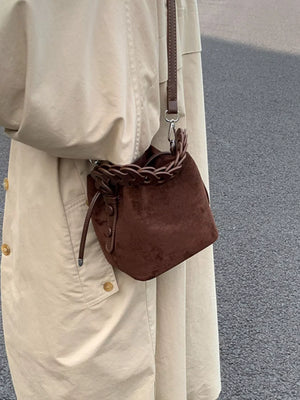 Brown mini crossbody bag with braided chain strap detail and adjustable leather strap.