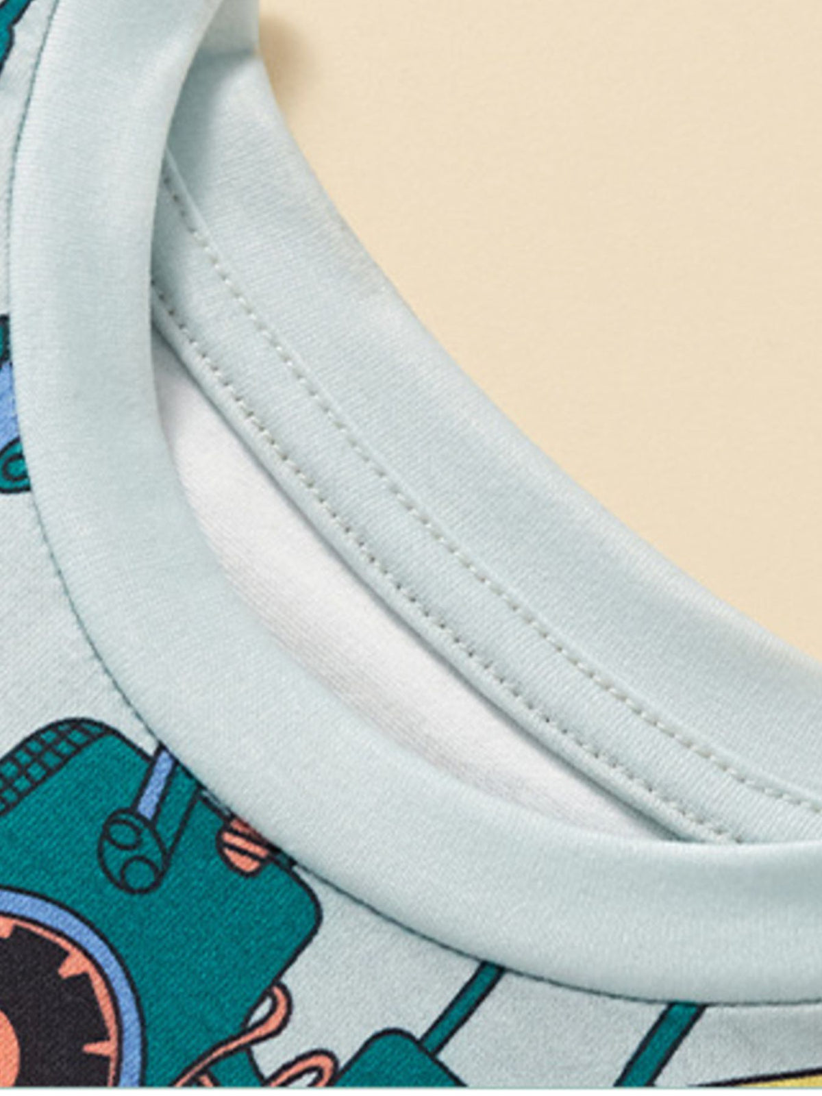 Light blue crew neck t-shirt with construction vehicle print and light blue trim.